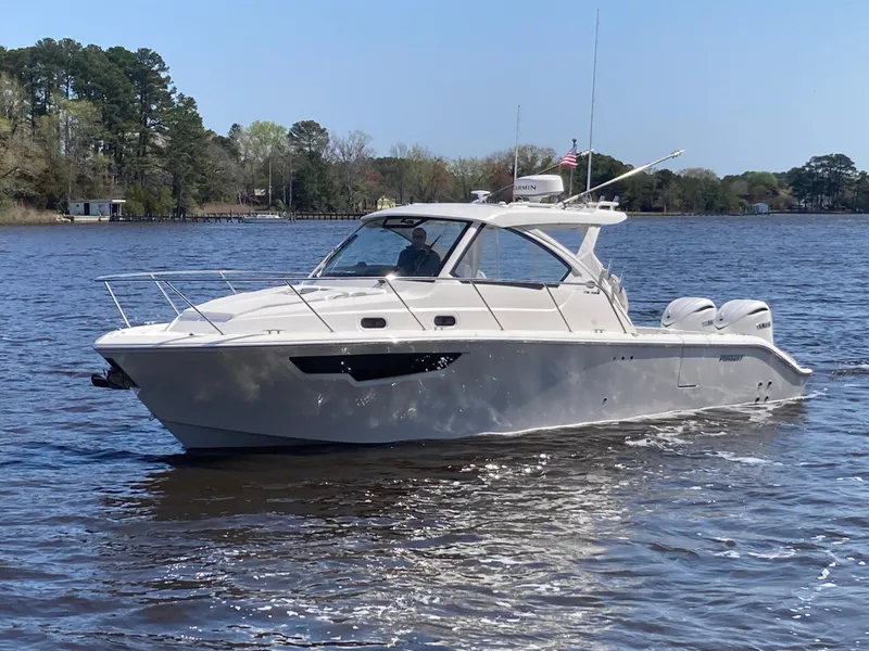 Slide: The Image of 2025 Pursuit OS 325 boat cruising on a calm lake with trees in the background. - 47