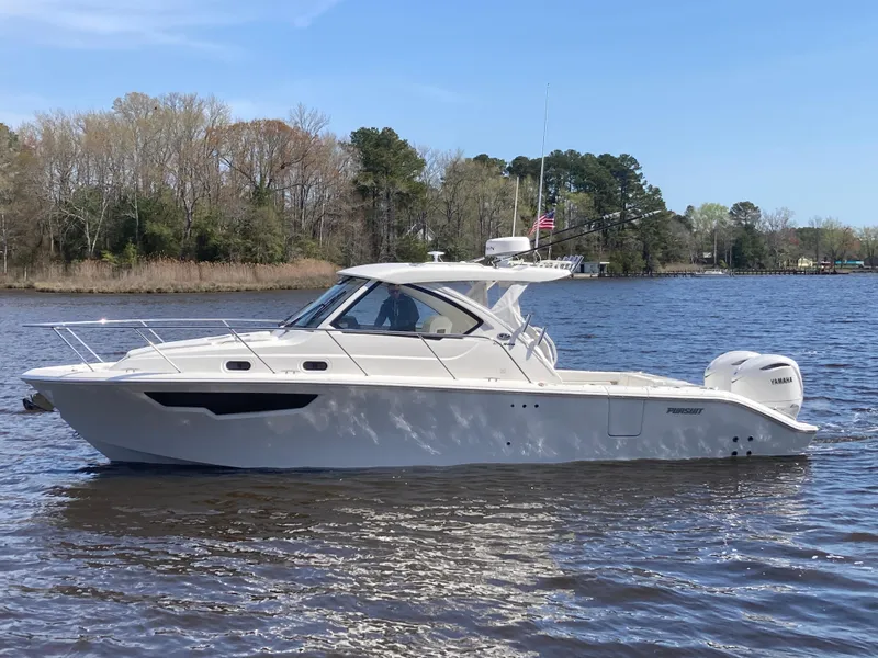 Slide: The Image of 2025 Pursuit OS 325 boat cruising on a calm lake with trees in the background. - 49