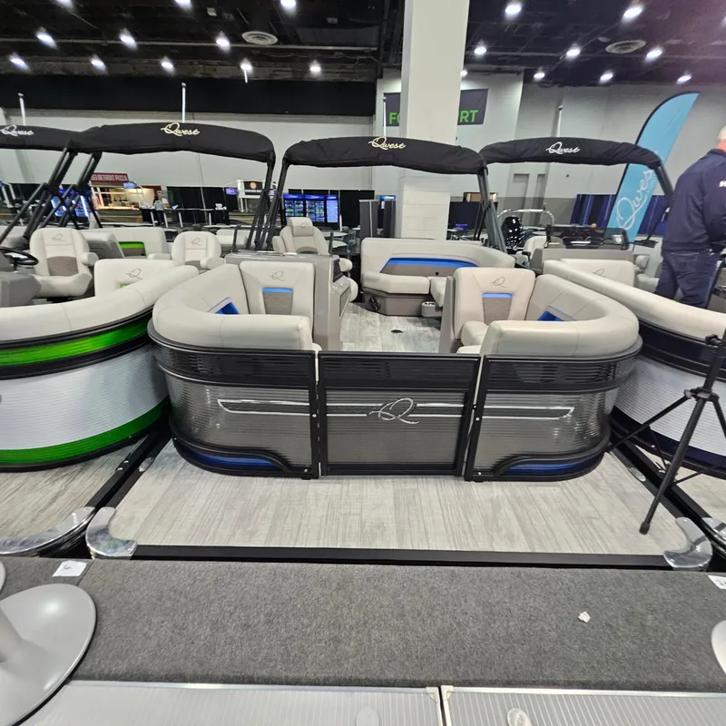 Slide: The Image of 2025 Qwest L18 Lanai pontoon boat displayed indoors with modern seating and sleek design. - 25