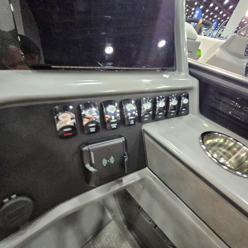 Slide: The Image of Control panel of 2025 Qwest L18 Lanai boat with switches and cup holder. - 9