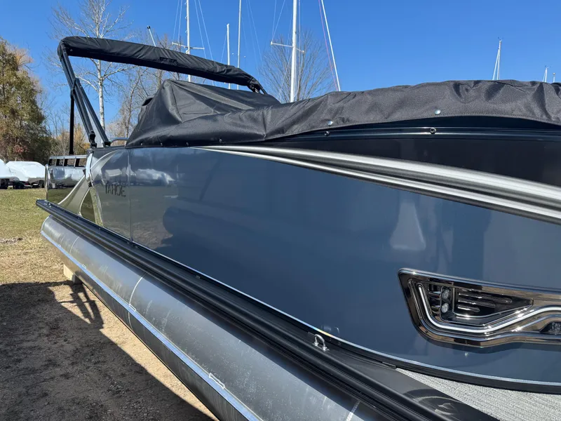 Slide: The Image of 2025 Tahoe Pontoon LTZ Versatile Rear Bench Windshield, sleek design, parked outdoors. - 3