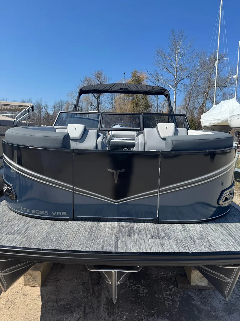 Slide: The Image of 2025 Tahoe Pontoon LTZ Versatile Rear Bench Windshield, sleek design, parked outdoors. - 8
