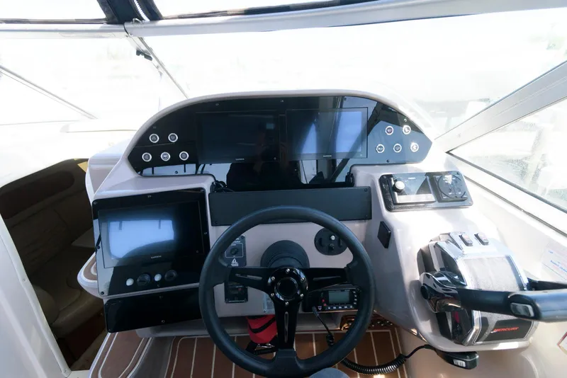 Slide: The Image of 2004 Rinker Fiesta Vee 312 boat dashboard with steering wheel and navigation controls. - 12