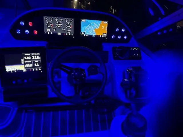 Slide: The Image of 2004 Rinker Fiesta Vee 312 boat dashboard illuminated with blue LED lights at night. - 13
