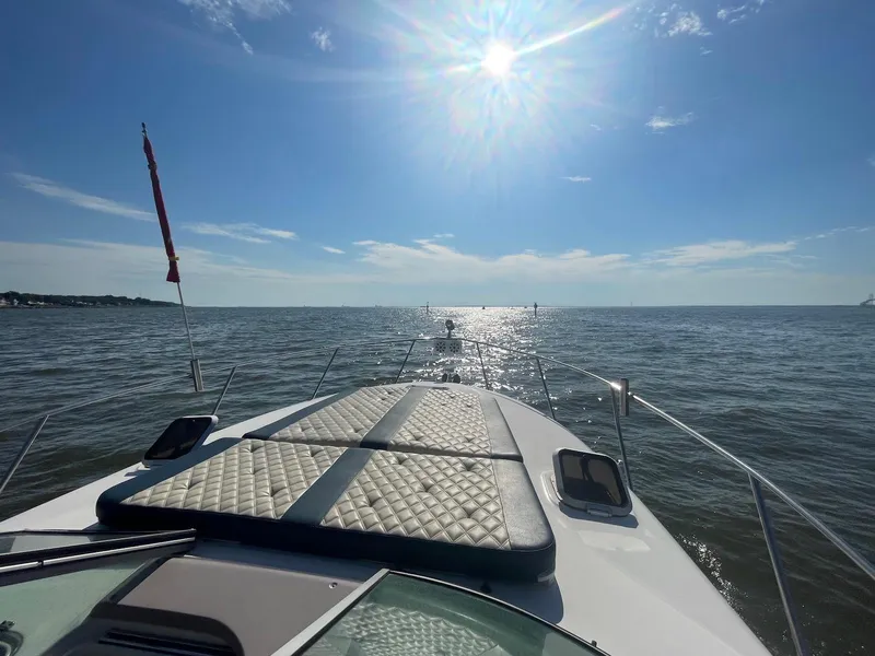 Slide: The Image of 2004 Rinker Fiesta Vee 312 cruising on open water under a bright sun. - 14