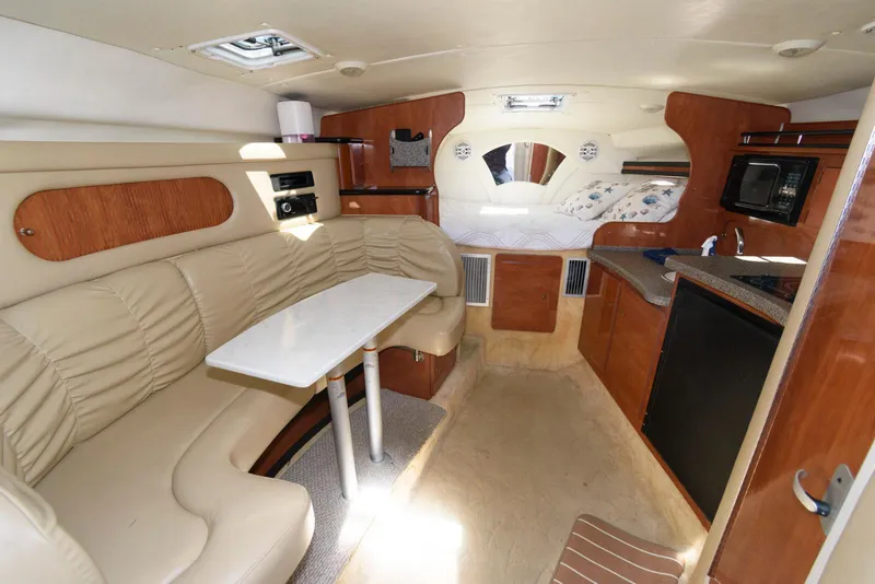 Slide: The Image of 2004 Rinker Fiesta Vee 312 cabin interior with seating, table, and kitchenette. - 17