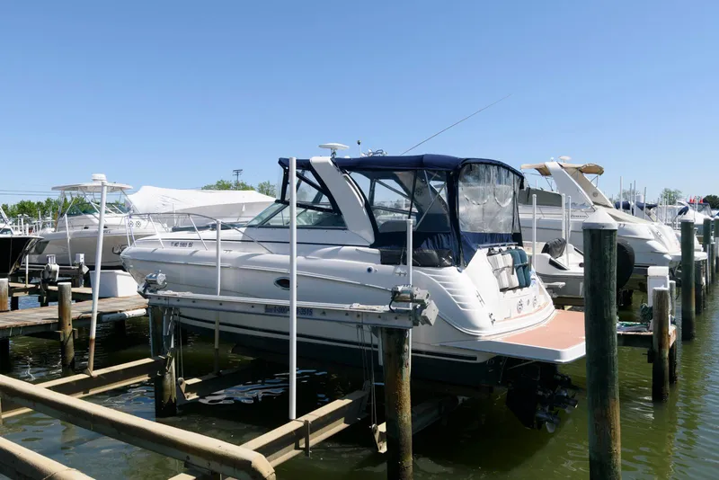 Slide: The Image of 2004 Rinker Fiesta Vee 312 boat docked at a marina under clear blue skies. - 4