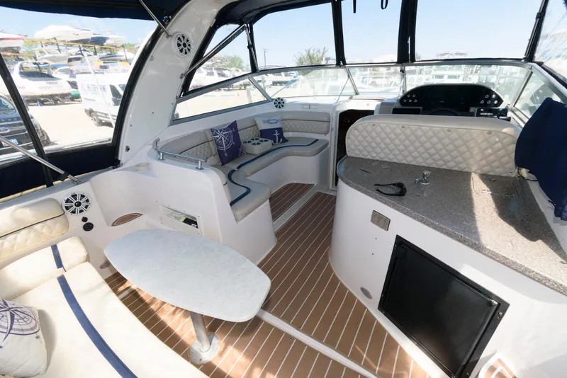 Slide: The Image of 2004 Rinker Fiesta Vee 312 boat interior with seating, table, and helm. - 5