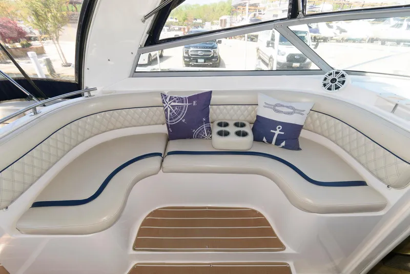 Slide: The Image of 2004 Rinker Fiesta Vee 312 boat interior with cushioned seating and nautical-themed pillows. - 8