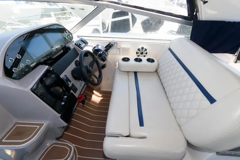 Slide: The Image of 2004 Rinker Fiesta Vee 312 boat interior with steering wheel, dashboard, and white seating. - 9