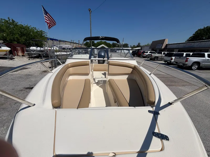 Slide: The Image of 2018 Scout 210 Dorado boat with beige seating, docked outdoors under clear blue sky. - 15