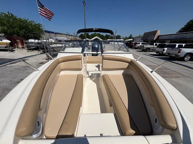 Slide: The Image of 2018 Scout 210 Dorado boat with beige seating, docked under clear blue sky. - 16