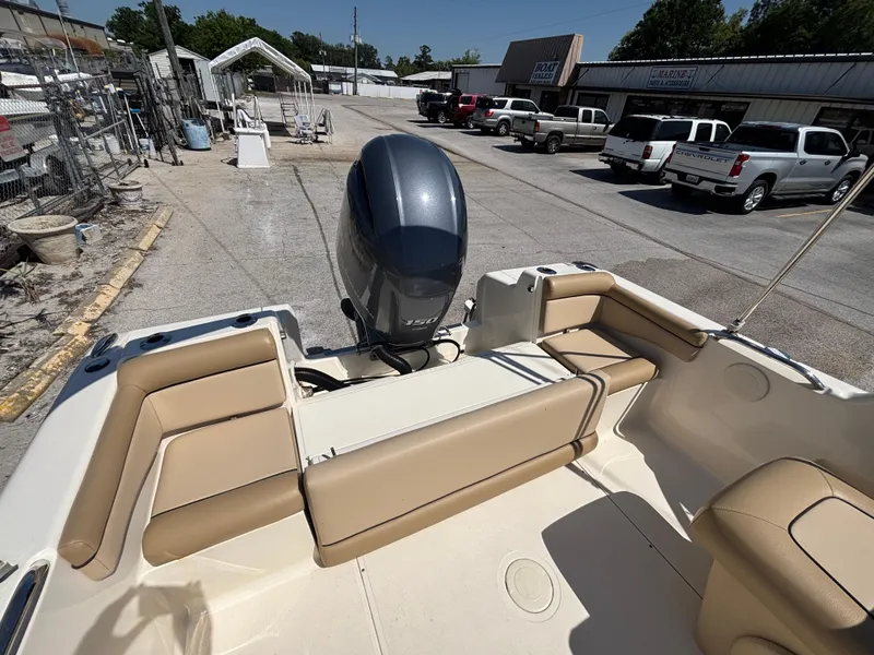 Slide: The Image of 2018 Scout 210 Dorado boat interior with beige seating and outboard motor. - 22