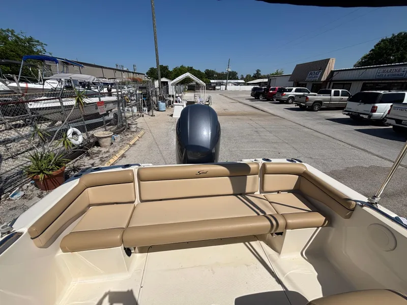 Slide: The Image of 2018 Scout 210 Dorado boat with tan seating, parked in a marina lot. - 23