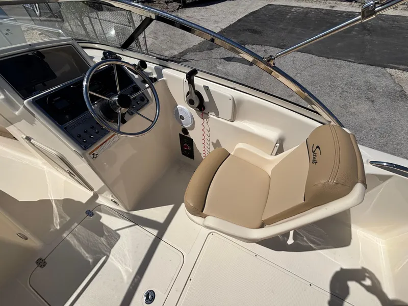 Slide: The Image of 2018 Scout 210 Dorado boat cockpit with steering wheel and beige seating. - 26