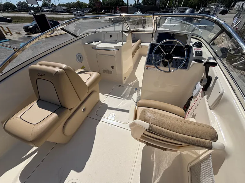 Slide: The Image of 2018 Scout 210 Dorado boat interior with beige seating and steering console. - 27