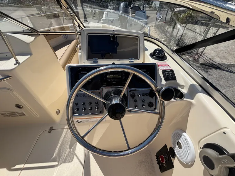 Slide: The Image of 2018 Scout 210 Dorado boat dashboard with steering wheel and navigation controls. - 28