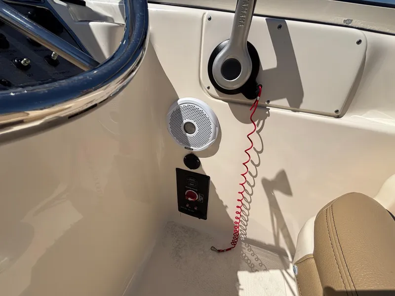 Slide: The Image of 2018 Scout 210 Dorado boat interior with steering wheel, speaker, and control panel. - 31