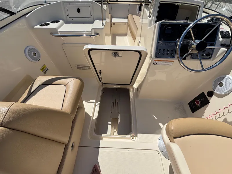 Slide: The Image of 2018 Scout 210 Dorado boat interior with beige seating and steering console. - 35