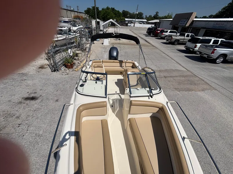 Slide: The Image of 2018 Scout 210 Dorado boat with beige seating, parked outdoors in a lot. - 47