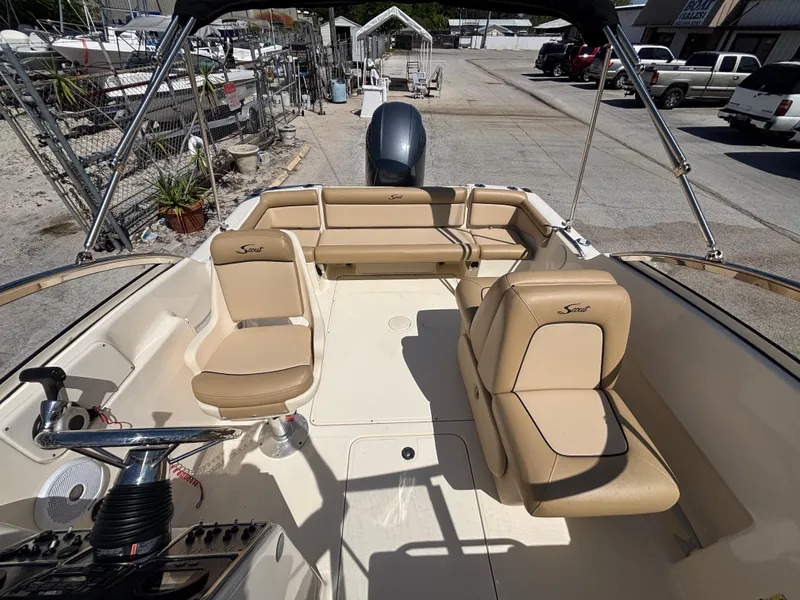 Slide: The Image of 2018 Scout 210 Dorado boat interior with beige seating and steering console. - 48