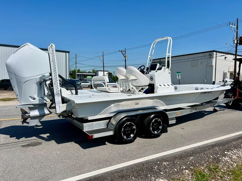 Slide: The Image of 2025 SCB S22 boat on trailer, parked outdoors, featuring a sleek white design and powerful outboard motor. - 4