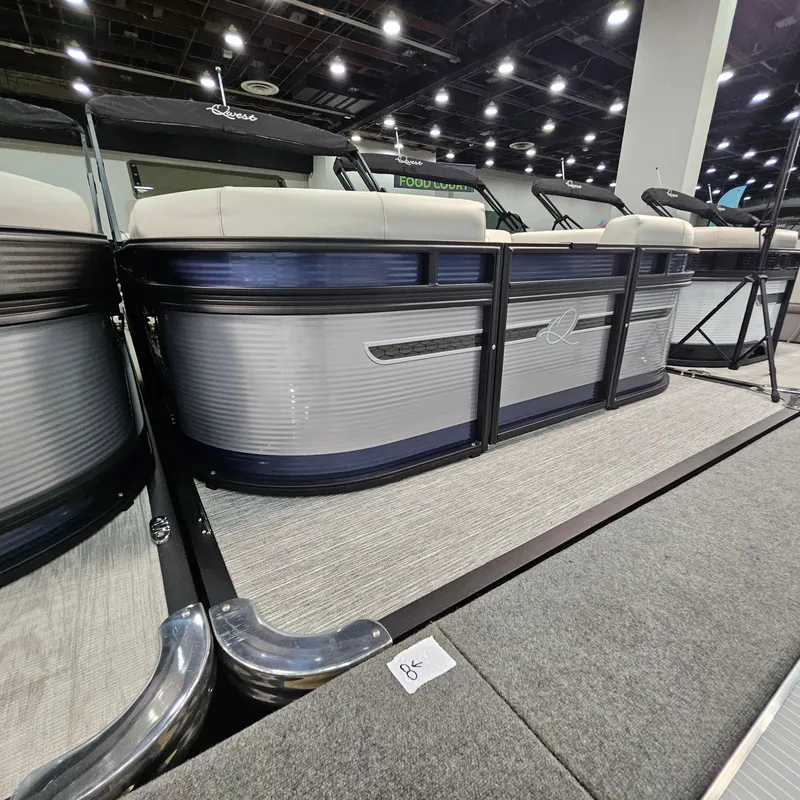 Slide: The Image of 2025 Qwest E 20RLS pontoon boat displayed indoors with modern seating. - 14