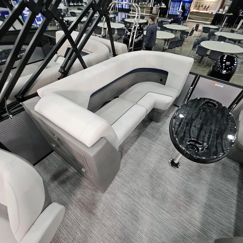 Slide: The Image of Luxurious interior of 2025 Qwest E 20RLS pontoon boat with plush seating and sleek table. - 21