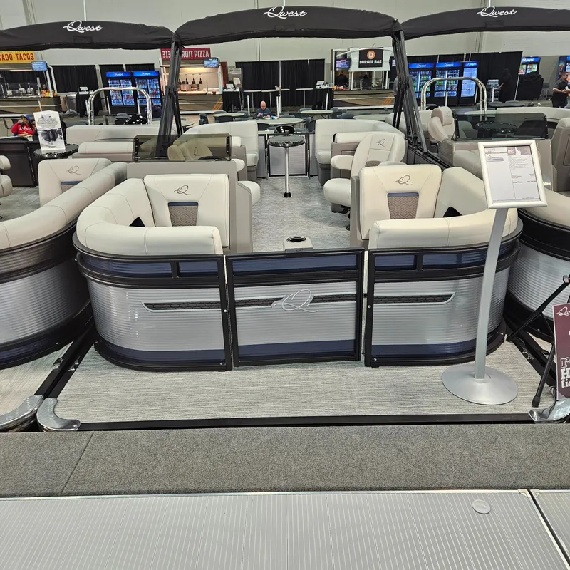 Slide: The Image of 2025 Qwest E 20RLS pontoon boat with luxurious seating at a boat show display. - 3