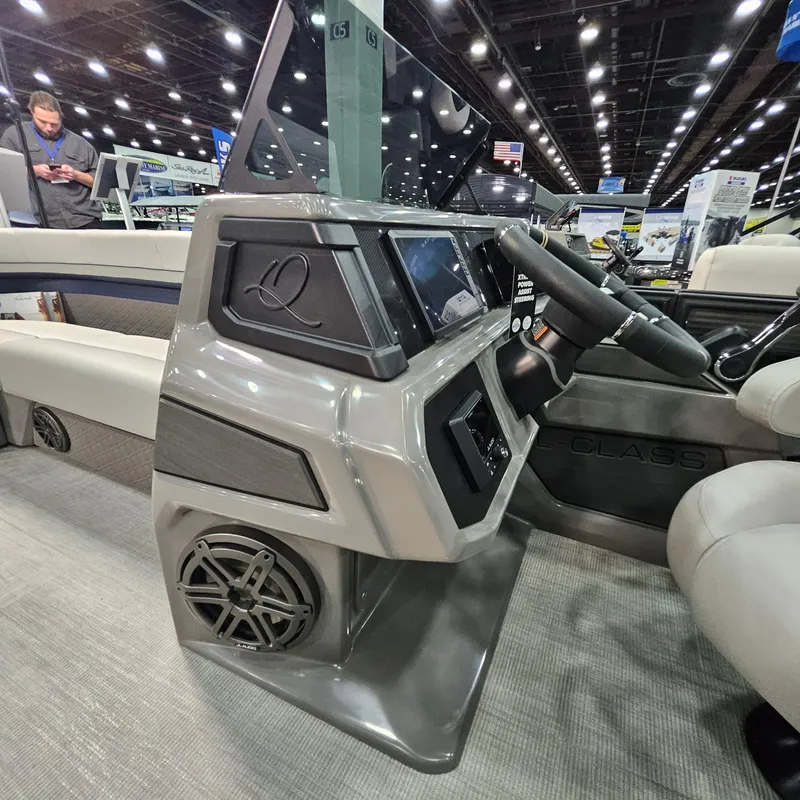 Slide: The Image of 2025 Qwest L22 Lanai boat dashboard with steering wheel and control panel at an indoor exhibition. - 13