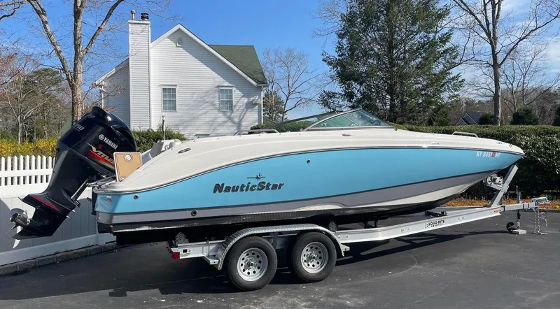 Slide: The Image of 2021 NauticStar 243 DC boat on trailer, parked in driveway near white house. - 4