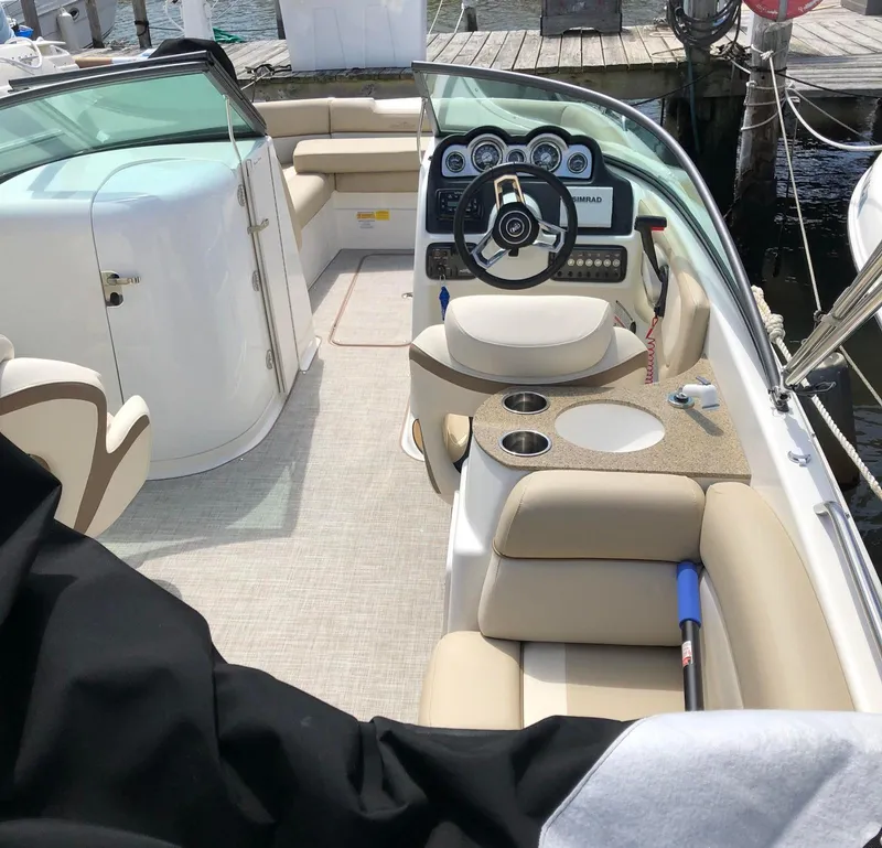 Slide: The Image of 2021 NauticStar 243 DC boat interior with steering wheel and seating area. - 7