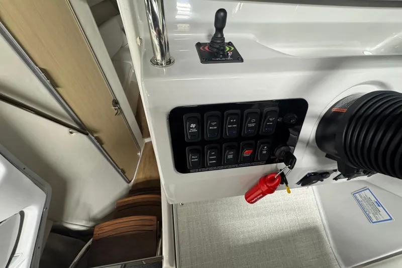 Slide: The Image of 2025 Regal 28 Express boat control panel with switches and ignition key. - 10