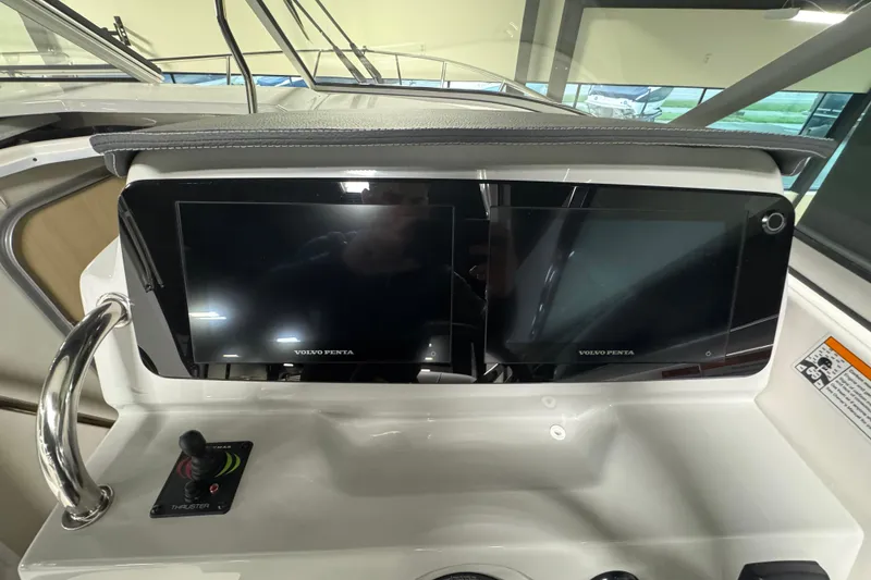 Slide: The Image of 2025 Regal 28 Express dashboard with dual Volvo Penta displays and joystick control. - 11