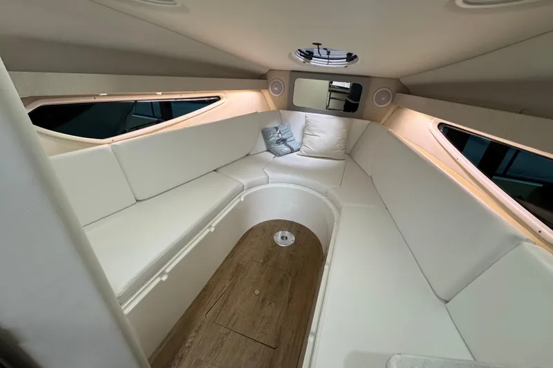 Slide: The Image of 2025 Regal 28 Express cabin interior with white seating and wood flooring. - 12