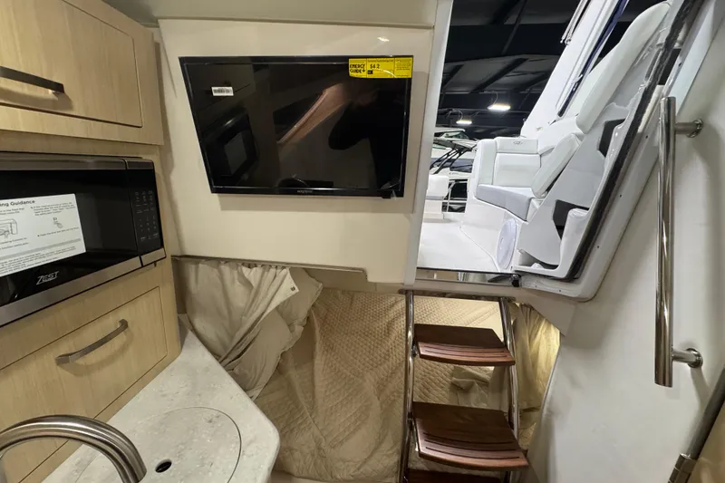 Slide: The Image of Interior of 2025 Regal 28 Express boat featuring kitchenette and seating area. - 16