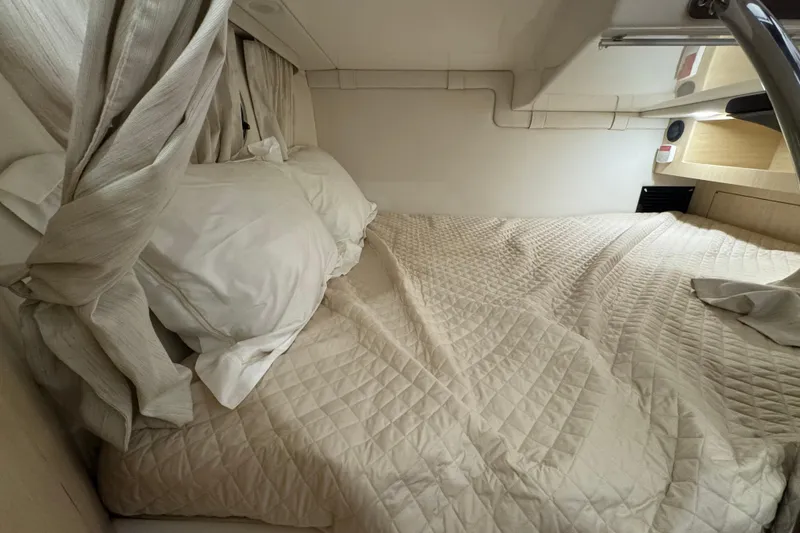 Slide: The Image of 2025 Regal 28 Express cabin interior with cozy bed and curtains. - 17