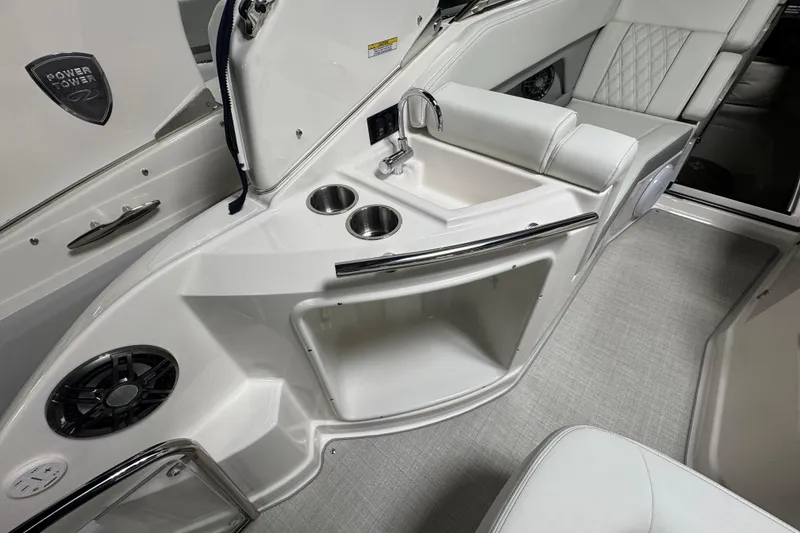 Slide: The Image of 2025 Regal 28 Express boat interior with sink, cup holders, and seating. - 6