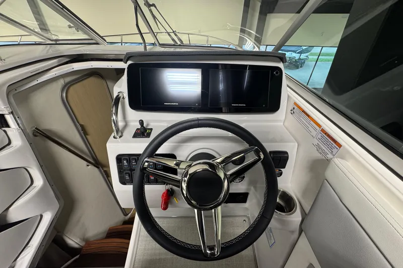 Slide: The Image of 2025 Regal 28 Express boat helm with modern steering wheel and digital display. - 9