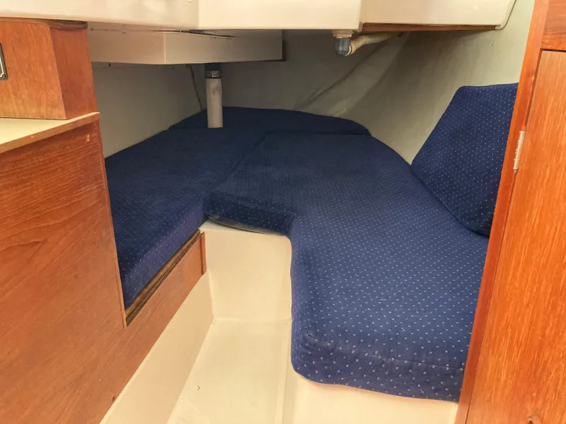Slide: The Image of Interior cabin of a 1984 Hunter 31 sailboat with blue cushioned seating. - 30