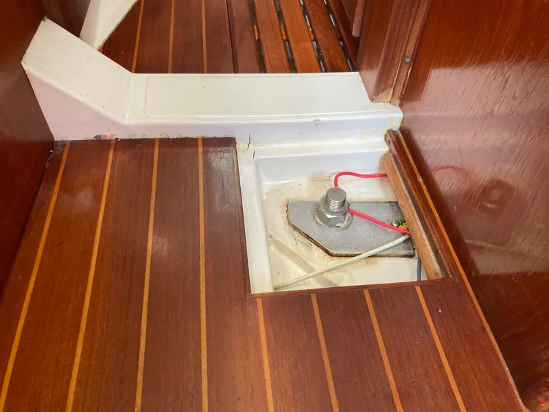 Slide: The Image of 1984 Hunter 31 sailboat interior with wooden flooring and visible bolt access. - 32