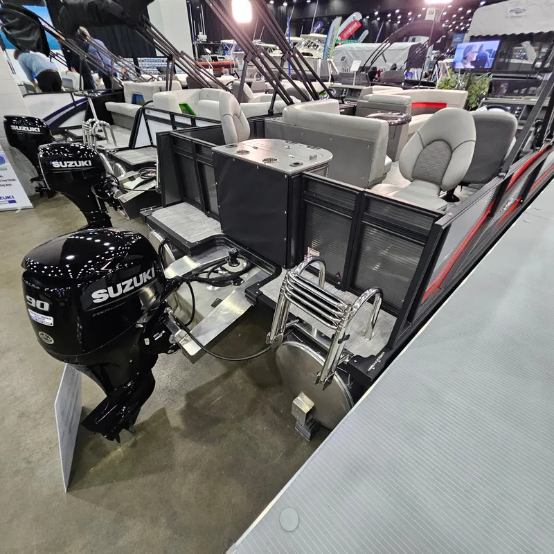 Slide: The Image of 2025 Qwest E 20XRE pontoon boat with Suzuki outboard motor, showcased at a boat exhibition. - 10