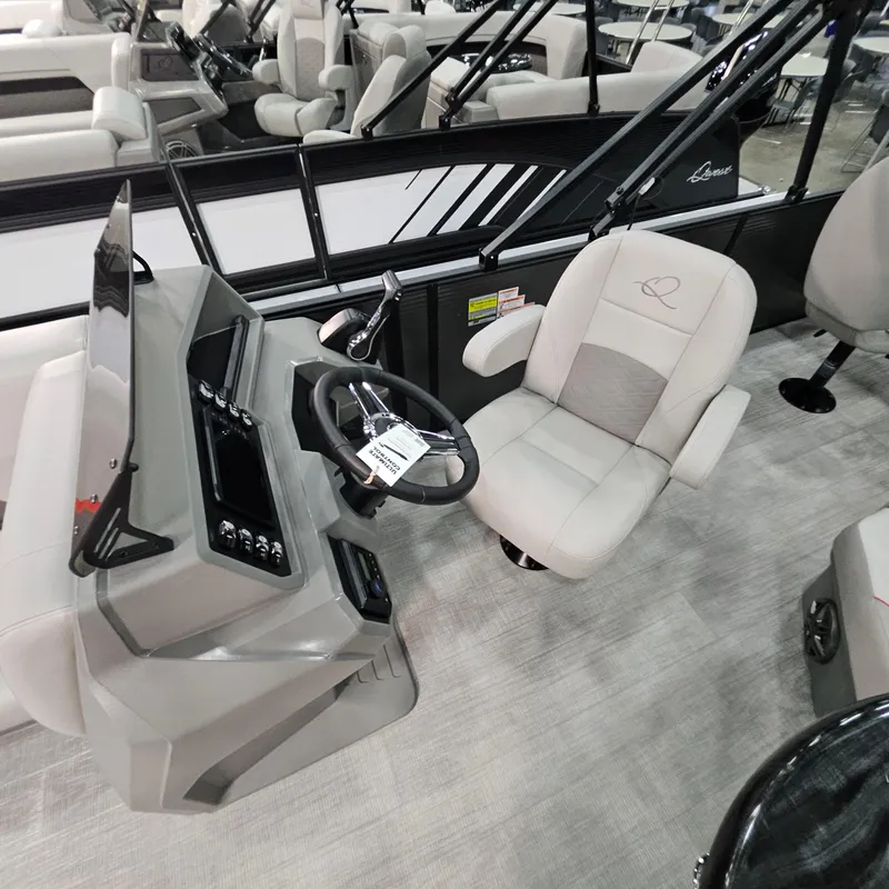 Slide: The Image of 2025 Qwest E 20XRE boat interior with steering console and cushioned captain's chair. - 23