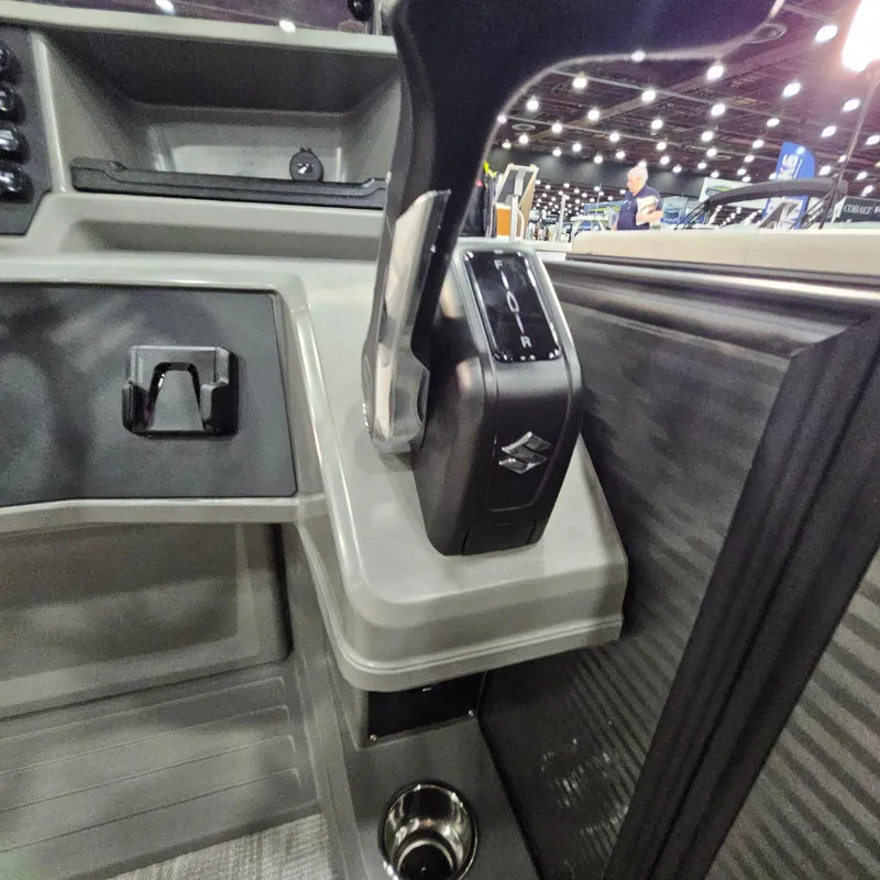 Slide: The Image of Control panel of 2025 Qwest E 20XRE boat with throttle lever and cup holder. - 33