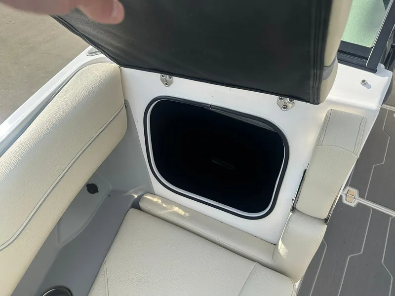 Slide: The Image of 2022 Regal LS4 Surf boat storage compartment with open lid, showcasing interior space. - 25