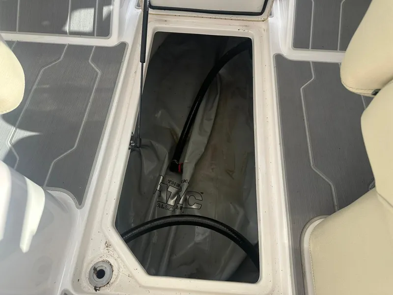 Slide: The Image of 2022 Regal LS4 Surf boat storage compartment with visible hose and interior details. - 40