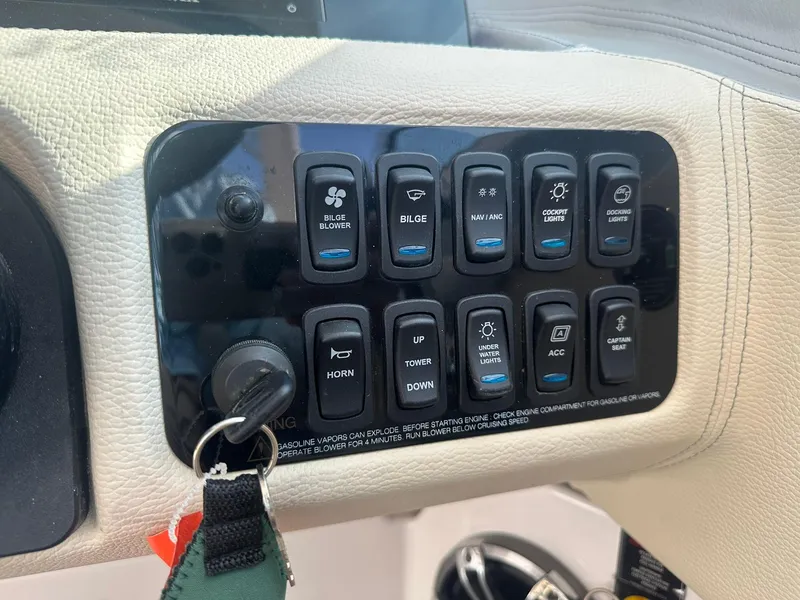 Slide: The Image of Control panel of a 2022 Regal LS4 Surf boat with various switches and key ignition. - 46