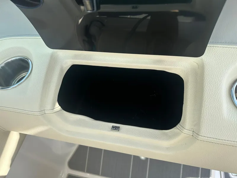 Slide: The Image of 2022 Regal LS4 Surf boat interior with cup holders and storage compartment. - 48