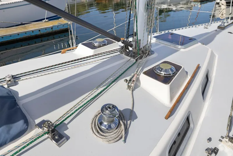 Slide: The Image of 1986 J Boats J/40 sailboat deck with winches and rigging, docked in calm waters. - 10