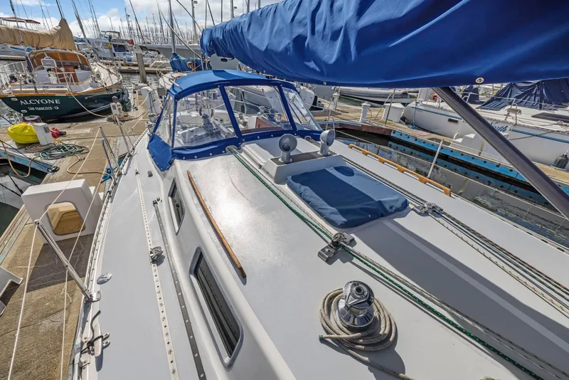 Slide: The Image of 1986 J Boats J/40 sailboat docked, featuring a blue canopy and clean deck. - 13
